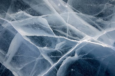 Donmuş bir gölün berrak, kalın buzunda çatlakların dokusu