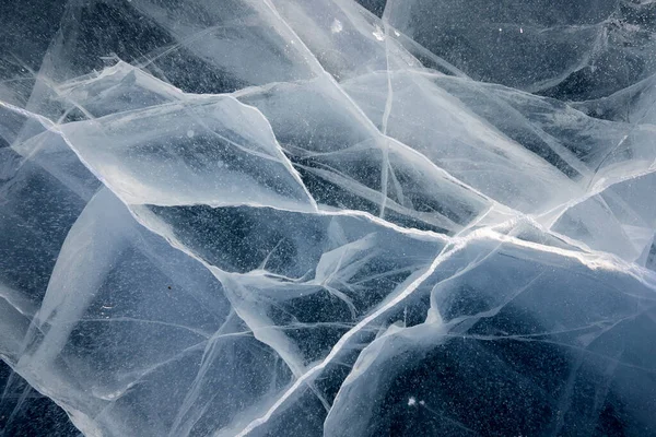 Texture of cracks in the clear thick ice of a frozen lake — Stock Photo, Image