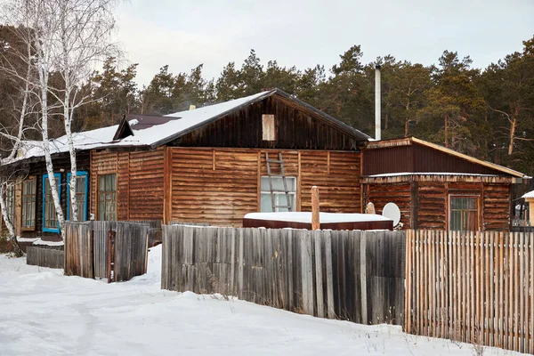 Houten huis in het bos omheind met hekwerk — Stockfoto
