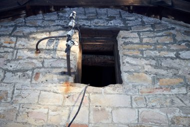Elektrikli yalıtımlı taş bir evin duvarında camsız bir yurt penceresi.