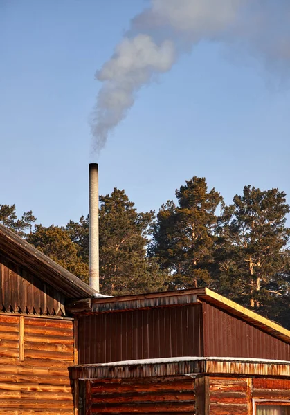 Rök som kommer från skorstenen i ett byhus — Stockfoto