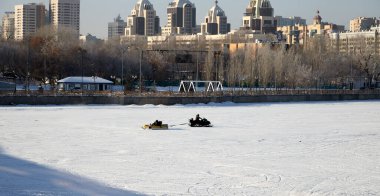 Nur-Sultan, 3 Ocak 2021 - Donmuş bir nehrin buzunda insanların sürdüğü şişme muz sürücüsü
