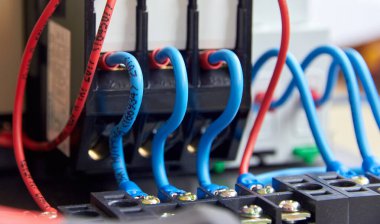 kontak paneline yüklenmiş kırmızı ve mavi elektrik kontakt kablolarının seçici odak noktası 