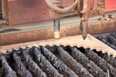 plazma kesme makinesi kesilmiş metal parçalarının üzerine nozül yerleştirir