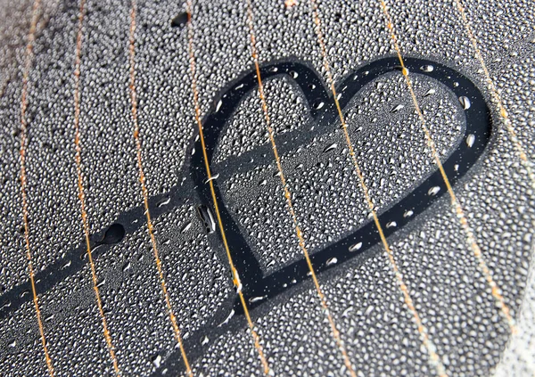 Σχέδιο μιας καρδιάς στο νερό σταγόνες στο πίσω παράθυρο του αυτοκινήτου. — Φωτογραφία Αρχείου
