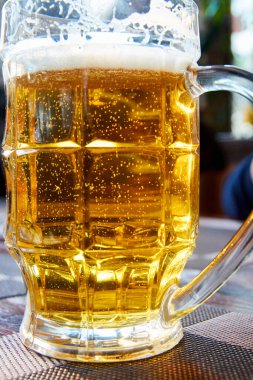 Bir kupa bira ve pipetle yakın plan. Biranın içinde gaz kabarcıkları