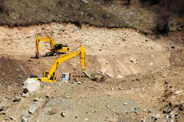 Kazıcılar bir dağ nehrinin kayalık kıyısını kazıyorlar.