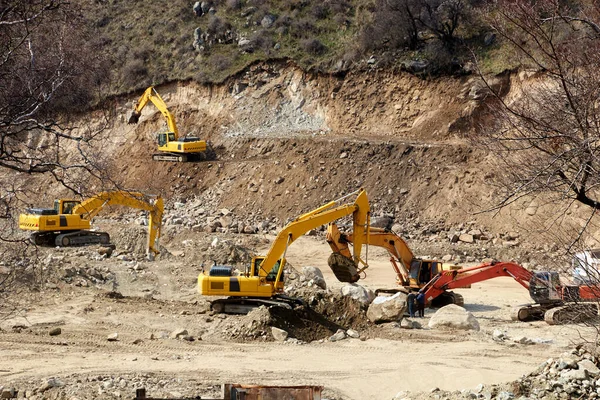 Kazıcılar bir dağ nehrinin kayalık kıyısını kazıyorlar.