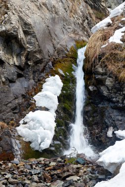 Bir dağ deresinde şelale. İlkbaharın başlarında kar eriyor