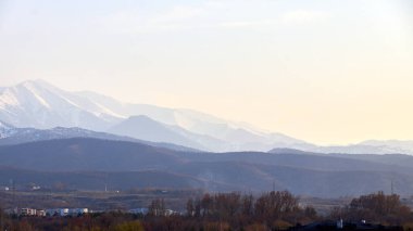 Gün batımında karla kaplı dağlar. uzak dağ manzarası