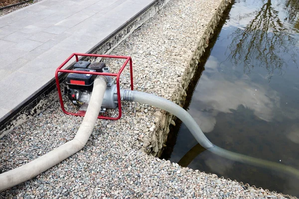 Portable pump that pumps water from the pond for watering the garden — Stock Photo, Image
