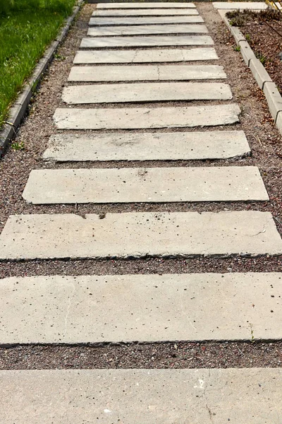 Jalan setapak di taman terbuat dari balok beton pada dasar batu hancur — Stok Foto