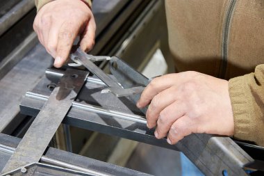 Ürünün boyutlarını daha hafif kalibre ile ölçen bir işçi. metal atölyesi