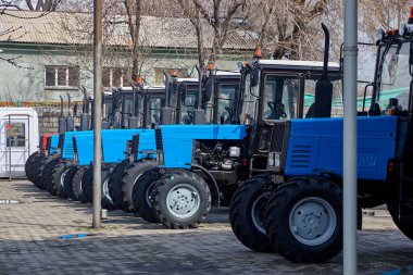 Çiftçiler için açık bir alanda satılık yepyeni tarım traktörleri. 