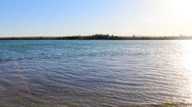 Güneşin doğuşuyla aydınlanan sakin bozkır nehrinin manzarası