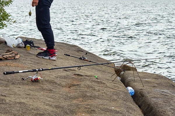 Fisherman with a fishing rods on the lake shore — Stock Photo, Image