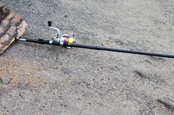 Vara de pesca com um movimento cambaleante deitado em uma rocha — Fotografia de Stock