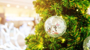 Gümüş top Noel ağacında sallanıyor.