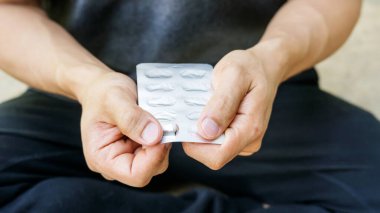 Beyaz hap kapsülü tutan adam..