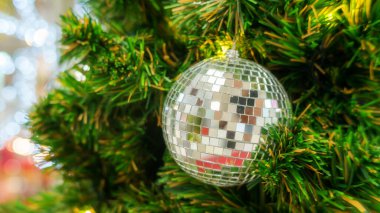 Gümüş top Noel ağacında sallanıyor.