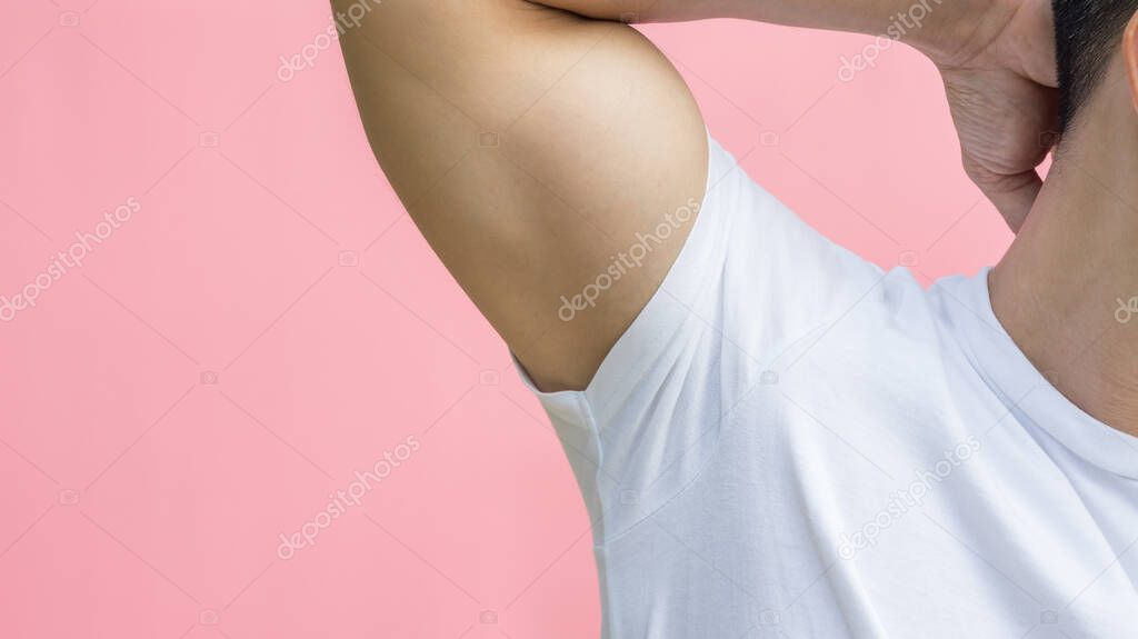 Men showing his armpit on a pink background.