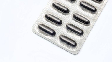 Beyaz arka planda siyah hap kapsülü, seçici odak.