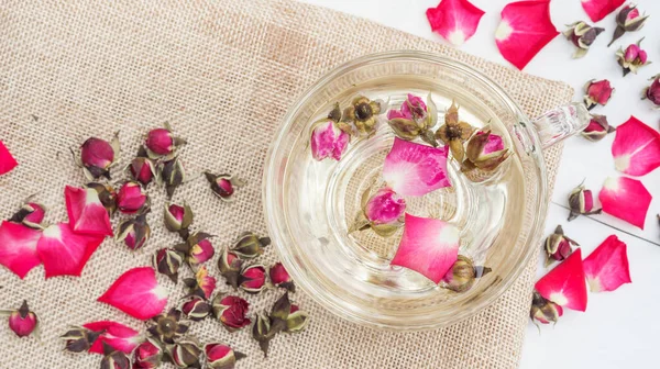 Beyaz ahşap bir masada pembe bir fincan çay..