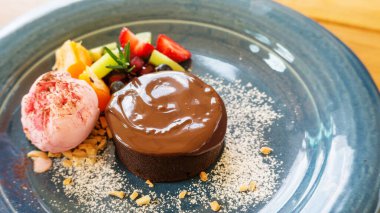 Çikolatalı kek lavı ve mavi tabakta çilekli dondurma..