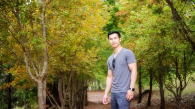 Akçaağacın önünde duran Asyalı genç adamlar..