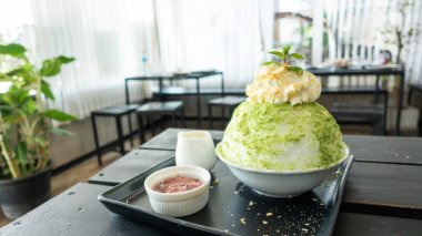 Tahta bir masada yeşil çay ve kırmızı fasulye Bingsu..