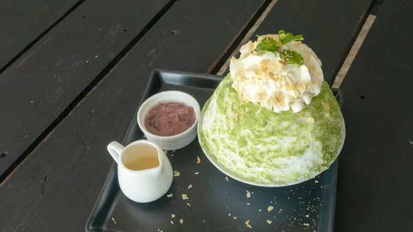 Tahta bir masada yeşil çay ve kırmızı fasulye Bingsu..