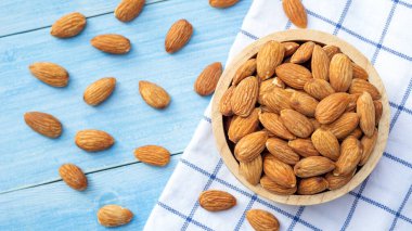 Mavi ahşap bir masada badem.