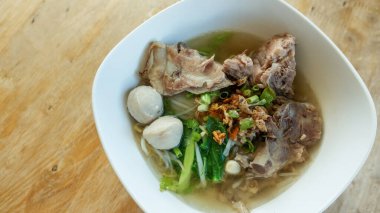 Tahta bir masada domuz kemiği eriştesi ve köfte (Tayland usulü)..