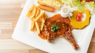 Beyaz tabakta domuz pirzolası..