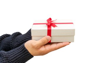 Beyaz arka planda gümüş bir hediye kutusu tutan adam..