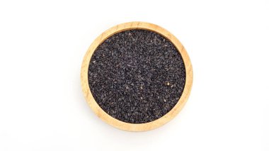 Siyah susam tohumları beyaz arka planda bir kasede.