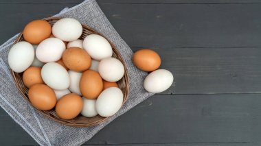 Tavuk yumurtası ve ördek yumurtası siyah ahşap bir masada..