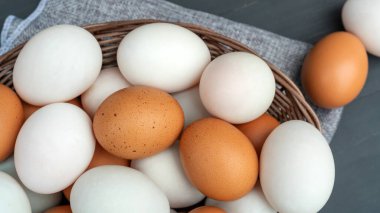 Tavuk yumurtası ve ördek yumurtası siyah ahşap bir masada..