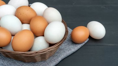 Tavuk yumurtası ve ördek yumurtası siyah ahşap bir masada..