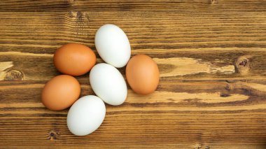 Tahta bir masada tavuk yumurtası ve ördek yumurtası..
