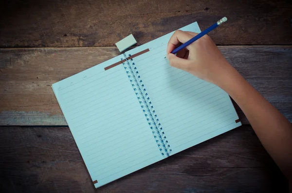 Escritura a mano en cuaderno abierto sobre mesa — Foto de Stock