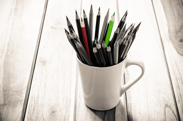 Stack of pencils in a glass on wooden background,tone sepia — Stock Photo, Image