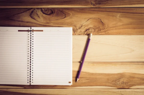 Lápices de color en las tazas y cuaderno colocado en un escritorio. — Foto de Stock