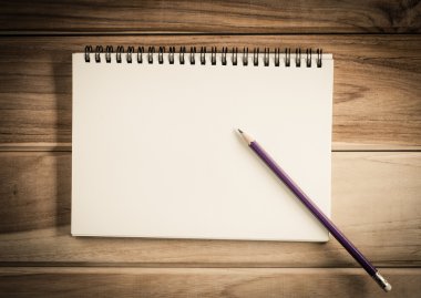 Ahşap masa üzerinde kurşun kalemle boş bir defter - natürmort