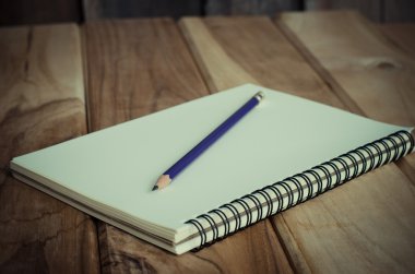 Ahşap masa üzerinde kurşun kalemle boş bir defter - natürmort