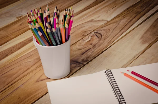Färgpenna och skissblock på träbord — Stockfoto