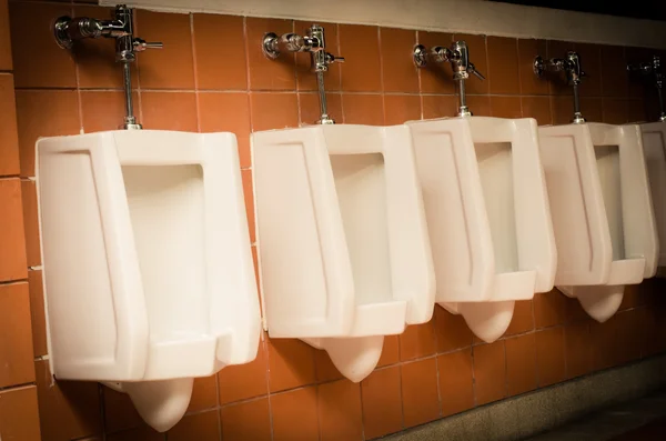 Muitos na casa de banho masculina urinol . — Fotografia de Stock