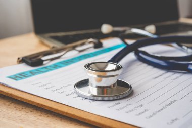 Sağlık sigortası belgelerine steteskop ve hesap makinesi yerleştirilmiş. Bireysel sağlık sigortası. Yaşam planlama kavramını