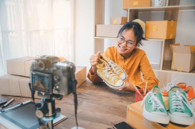 Çevrimiçi küçük işletme sahibi canlı yayınları, ürün değerlendirmelerini, ikinci el ayakkabıları kaydederek çalışıyor. Ve çevrimiçi ürünler satmak
