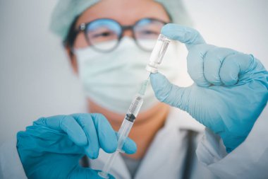Şırıngalı doktor hastaya aşı yapmaya hazır. Aşılama kavramı.